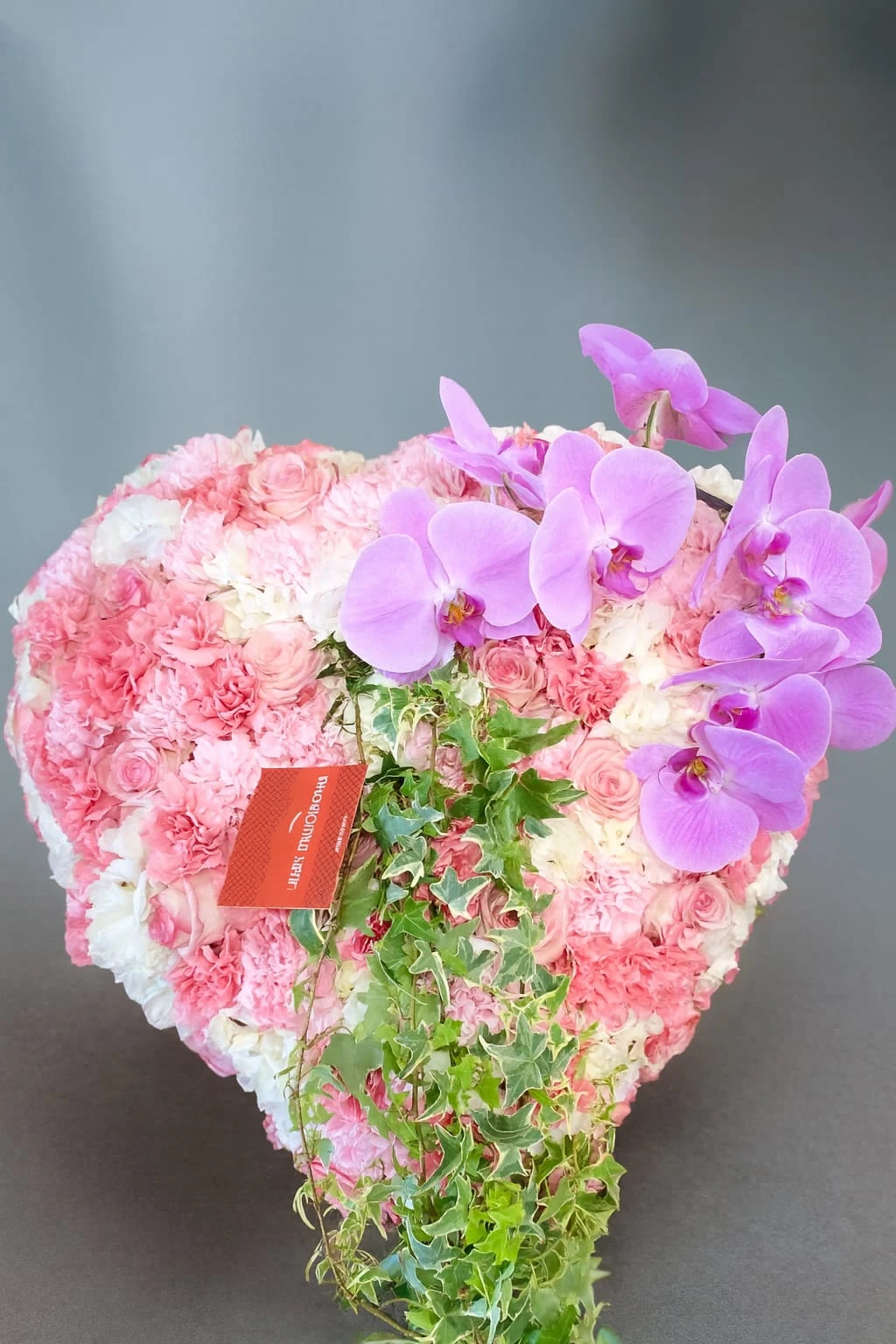 Cœur de deuil composé d'orchidées blanches